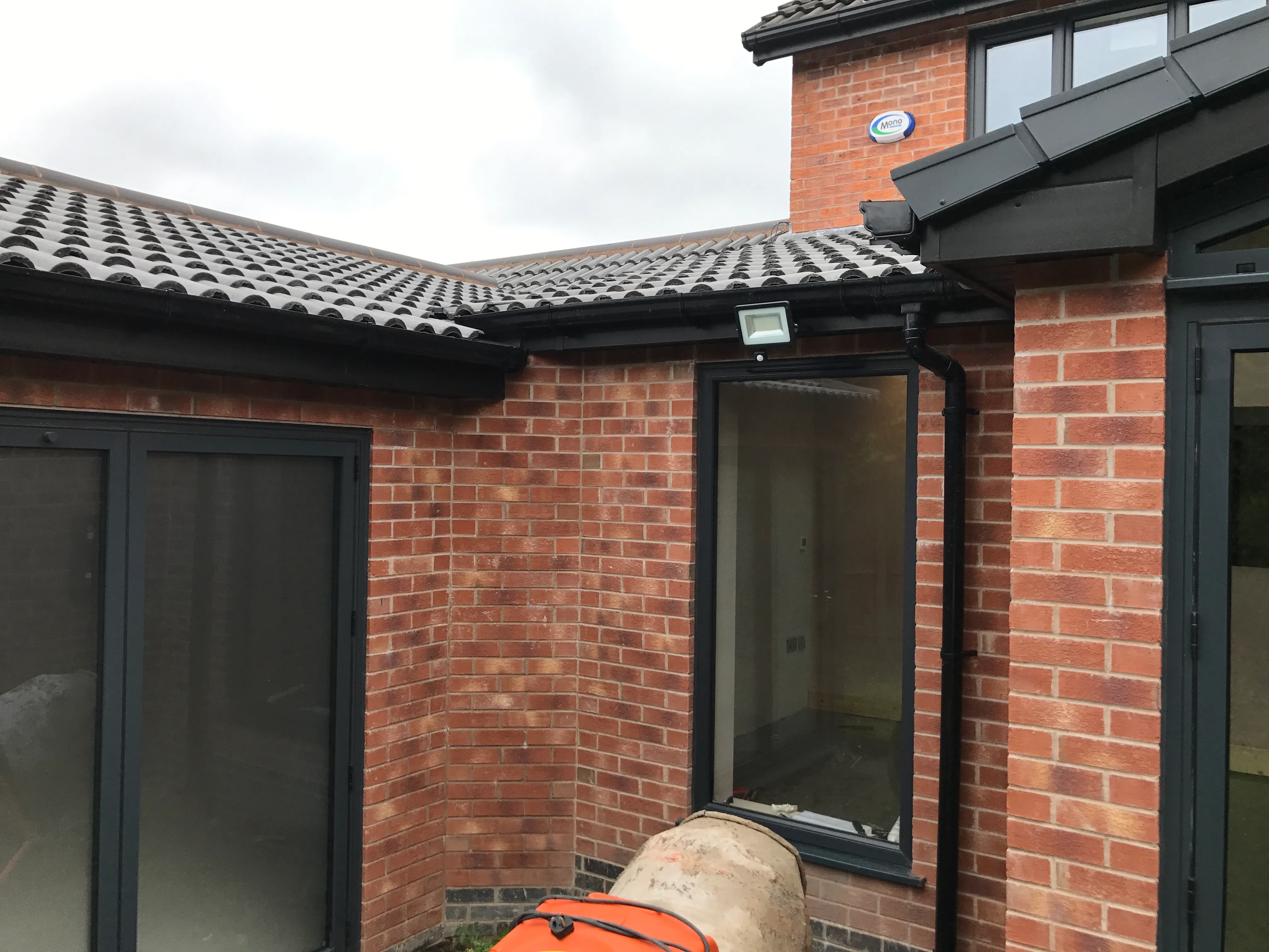 Flat-roof rear extension: Rendered box extension with anthracite glazing and open deck.