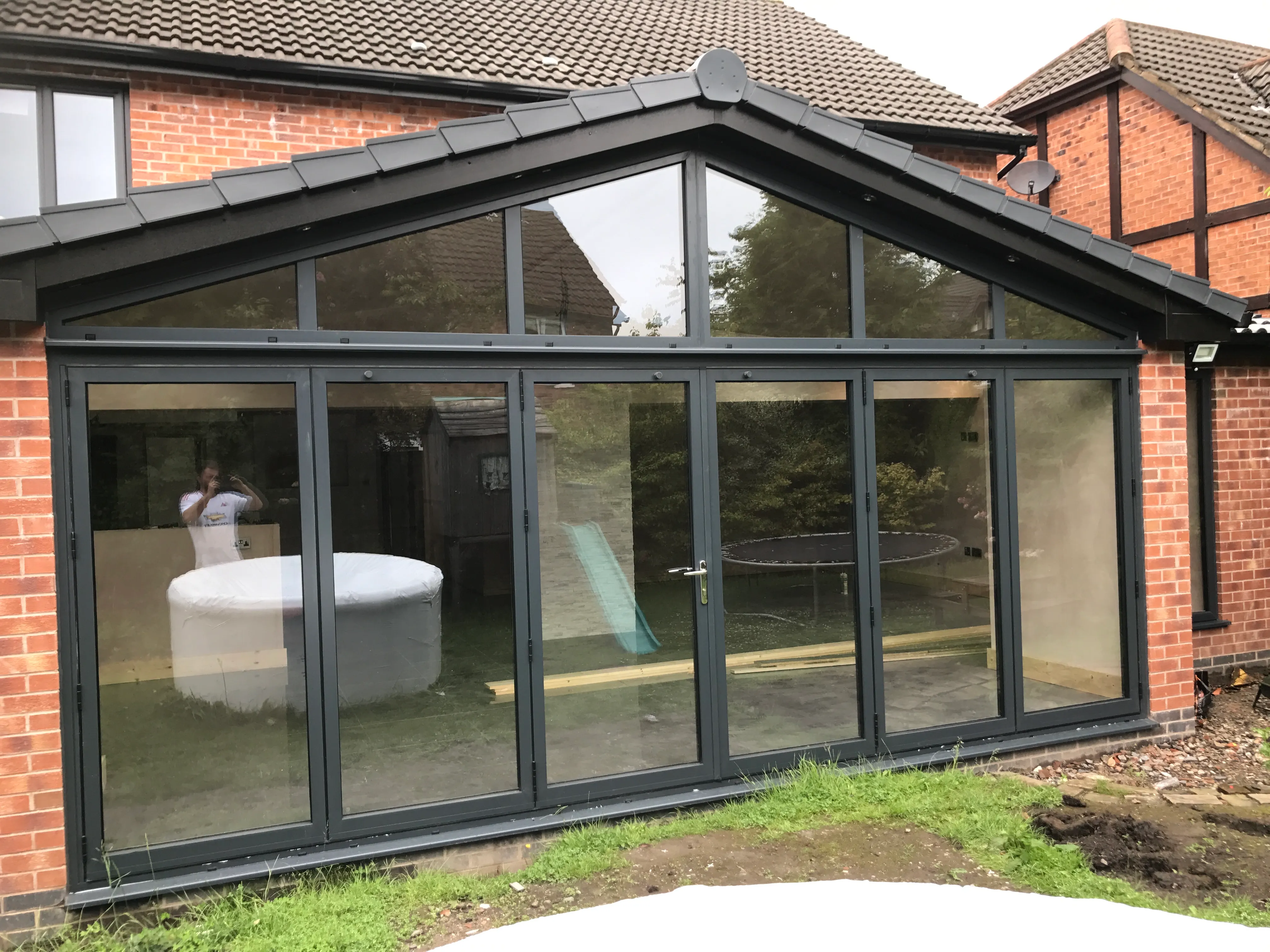 Pitched-roof glazed extension on a brick house