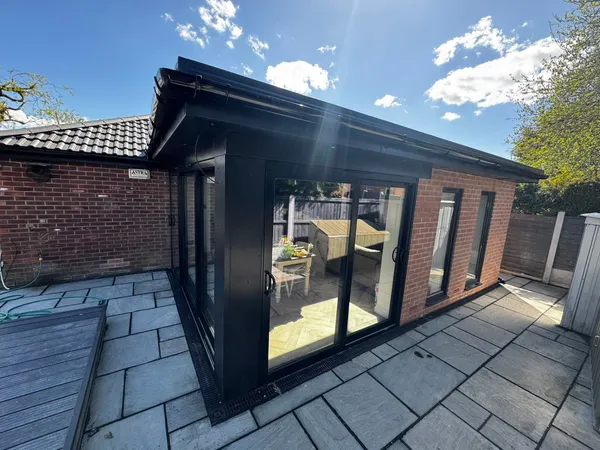 Completed garden room with black-framed sliding doors
