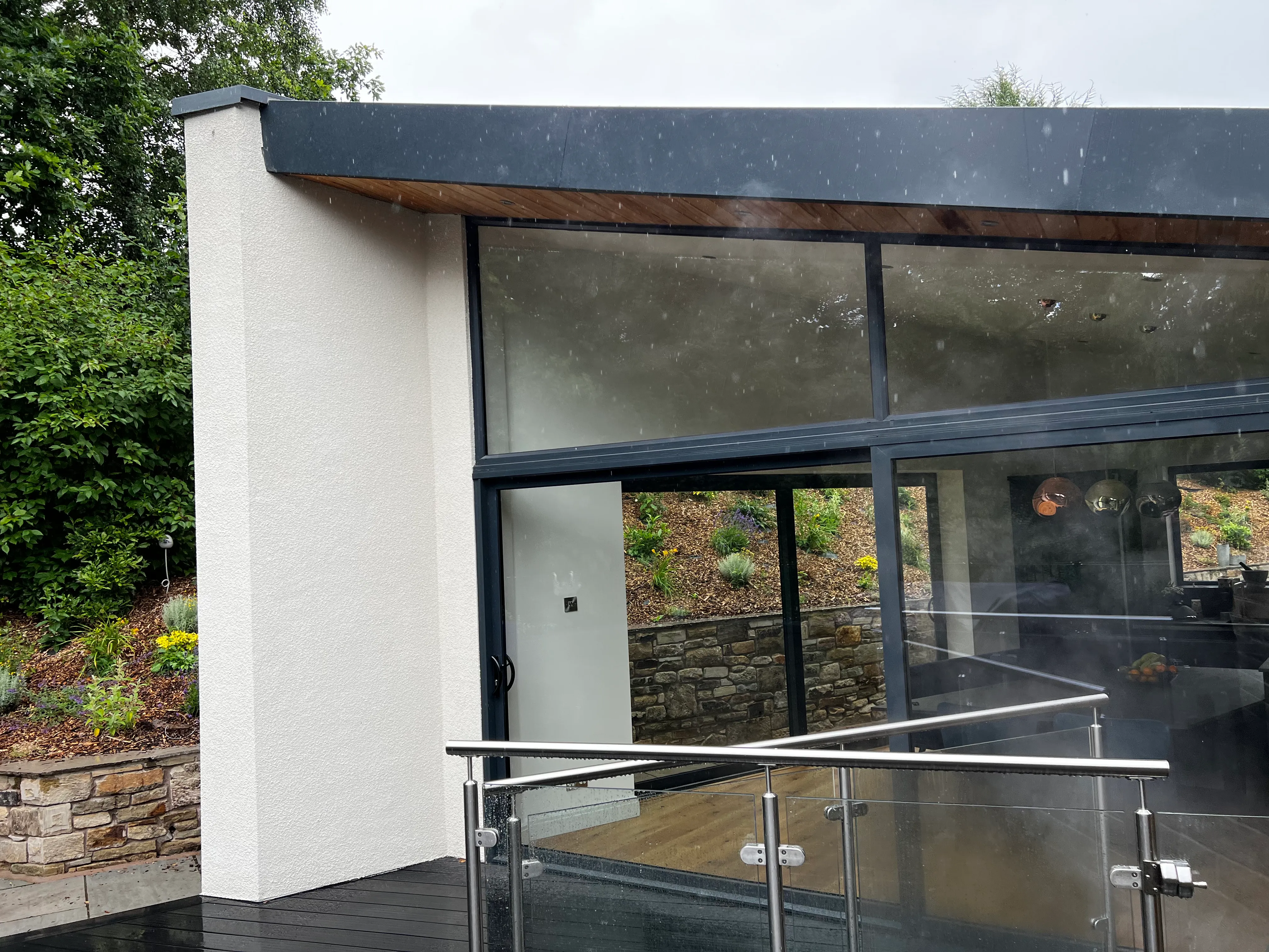 Rendered extension with anthracite glazing and a composite deck